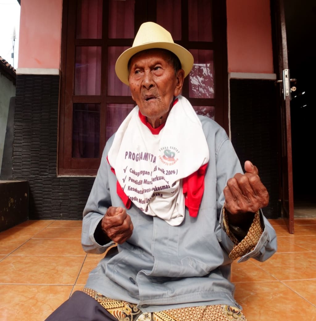 Uncle Mito, who says he is 120 years old, seated outside his home in East Java.